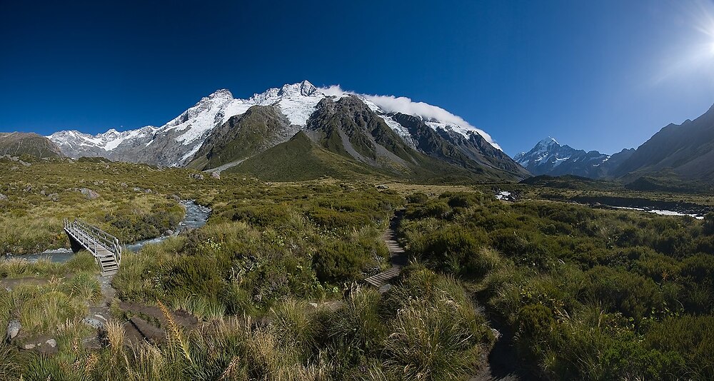 The Main Divide with Mt. Sefton and The Footstool, view from Hooker Valley. On the right side in the background the highest peak in New Zealand - Mt. Cook. Panorama stitched from 5 portrait format images. Some lens flares ans the shadow of the tripod were removed in post-processing.