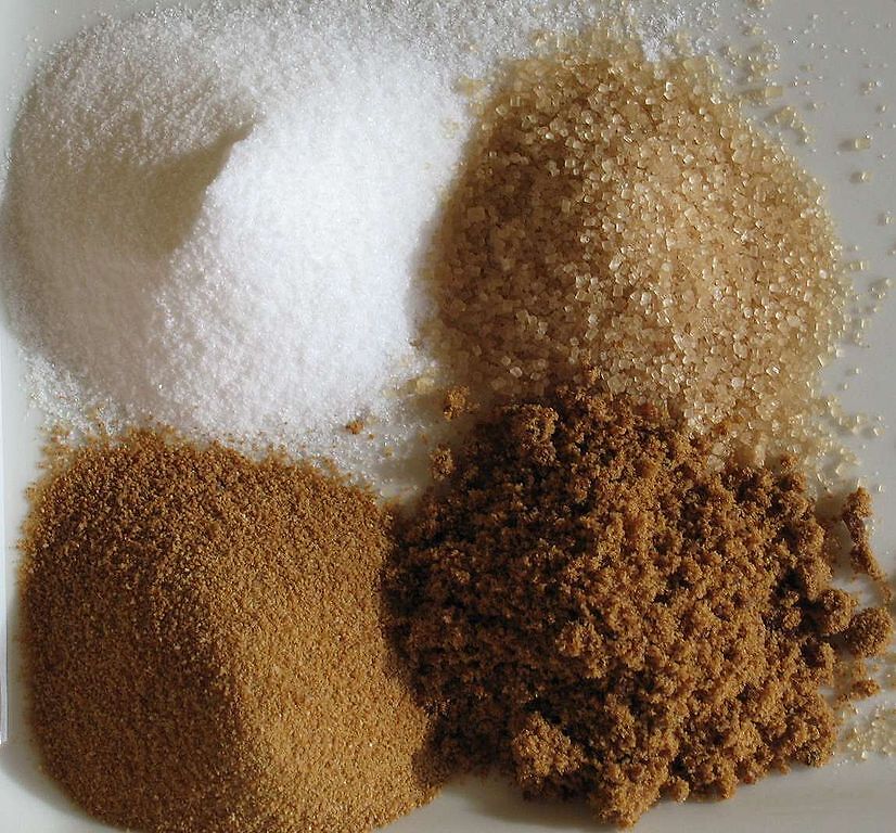 Sugars; clockwise from top left: White refined, unrefined, brown, unprocessed cane